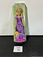 Front view of the Rapunzel doll in packaging, showing the purple dress and doll's face.