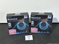 Two boxed packages of Merkury NeonGlo LED Rope Lights showing front packaging, indicating multicolor LED rope lights, 9.8 feet length.