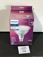 Front of Philips LED light bulb packaging showing 90W incandescent replacement, 10W LED, dimmable, bright white