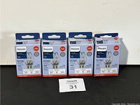 Four Philips halogen bulb packages arranged in a row, showing front packaging with bulb images