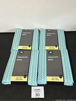 Four Hometrends brand packaged tablecloths with visible front size label showing pattern and dimensions.