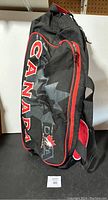 Side view of black Team Canada hockey bag with red zippers and Canada logo