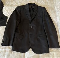 Front view of blazer laid flat showing notch lapels, single-button front, flap pockets