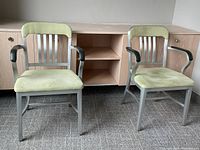 Two aluminum armchairs side by side showing full front view, chartreuse upholstery and slatted backs