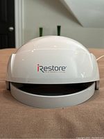 Front view of white iRestore dome helmet with logo