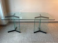 Front view of rectangular glass dining table showing full tabletop and supports