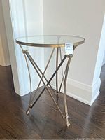Full front view of table showing glass top and brass frame