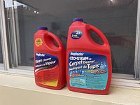 Two bottles of RugDoctor carpet cleaning detergent, one Steam Cleaner and one Oxy-Steam Carpet Cleaner, approx 3/4 full each, with purple caps.