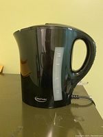 Side view of black Betty Crocker electric kettle with water level indicator, showing device in good used condition.
