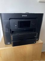 Front view of black Epson WorkForce Pro WF-4730 inkjet multifunction printer with screen and paper trays visible.