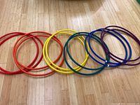 12 hula hoops in 6 rainbow colors laid out on floor