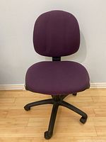 Front view of purple padded office chair, showing seat and backrest upholstery, and five-leg castor base.