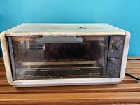 Front view of the vintage Black & Decker Toast-R-Oven TR0400 toaster oven unit, showing the glass door, door handle, and control panel with dials.