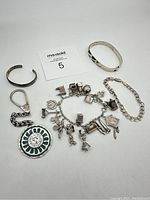 Full view of all bracelets and charm bracelet with detailed charms.