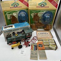 Lot showing two unopened Cabbage Patch Kids Western Collection outfit sets, battery operated Western Special Locomotive with original box, Embeco and Milton Bradley crayons, Dixon Cabinet box, and small toy tractor parts.