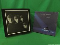 The Beatles collectible CD holder box and The Music Of Disney CD album side by side on a green background