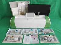 Front view of Cricut Expression 2 machine, 5th Anniversary Edition, with all included accessories arranged in front, including cartridges, cutting blade, stylus, vinyl pack, and carrying case.