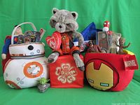 Front view of entire lot showing Rocket Raccoon plush, BB-8 container, Ironman bag, plush toys, and various action figures.