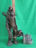 17-inch Treebeard figurine holding Merry and Pippin, standing next to a miniature Minas Tirith trinket box, set against a green backdrop for clear display.