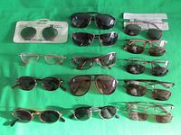 Full lot overview showing all 12 sunglasses including unopened Polaroid lenses and a mix of frame styles and colors.