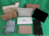 Nine purses and clutches arranged on a flat surface showing variety of brands, sizes, and colors including ivory, tan, brown, black, and green