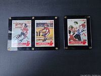 Three autographed 1976 Canada Cup hockey cards in framed holders, featuring Bob Gainey, Lanny McDonald, and a Canada Cup Camp team photo.