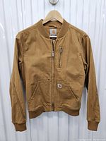 Front view of brown Carhartt bomber jacket with zipper, ribbed collar and cuffs, and pockets.