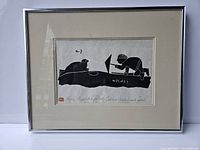 Framed Inuit art print showing Eskimo hunter and seal in black and white, viewed from front.