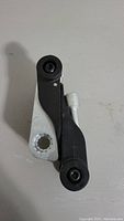 Top view of bike spoke wrench tensioner handle part of the tool showing black plastic and silver metal parts.