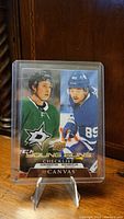 Front of Upper Deck Canvas Young Guns hockey checklist card showing Jason and Nick Robertson in team jerseys, encased in a plastic protective sleeve and displayed on a stand.