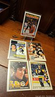 Five Mario Lemieux hockey cards displayed on a wooden surface, showing various portraits and action shots from his career with the Pittsburgh Penguins.
