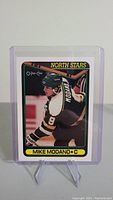 Front of Mike Modano rookie card in protective case, showing player in black North Stars jersey number 9.