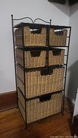 Front view of wicker storage unit with visible 6 wicker drawers and black metal frame.