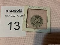 1925 Standing Liberty quarter coin in cardboard flip holder showing obverse side with Liberty figure and date