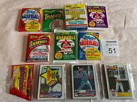 Photo showing sealed vintage baseball trading card packs and four individual cards in protective sleeves, clearly displaying brand logos, years, and player images on cards.