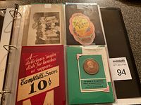 Photo showing a page with a sepia-toned group photo of children, a colorful Campbell's Soup advertising card, a Robert E. Lee souvenir medal card, all stored inside a plastic sheet protector in a binder.