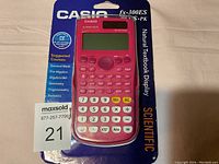 Pink Casio fx-300ES scientific calculator in plastic packaging with cardboard backing listing the calculator features and suitable courses.
