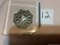 Coin front showing bird design and inscription ONE OUNCE PURE SILVER 999 enclosed in acrylic block