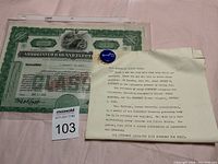 Photo showing the political pin, stock certificate, and typed letter placed side by side on a surface.