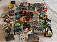 Wide shot of assorted trading cards spread on a table, showing multiple stacks and loose cards with colorful comic art including Marvel characters