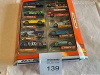Top-front view of the 10 Matchbox cars in original sealed packaging, showing the series names and a variety of car styles and colors.