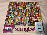 Photo of puzzle box showing colorful grid of vintage soda cans with 1000 piece count and Springbok branding.