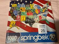 Box front of a Springbok 1000 piece puzzle showing the USA map made up of different state license plates on an American flag background, sealed in original shrink-wrap.