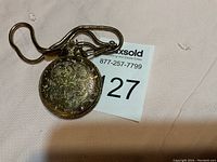 Ornate engraved exterior case of the vintage pocket watch with attached chain.