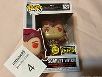 Front view of Scarlet Witch Funko POP! 823 collectible figure inside original box with visible labels and glow in the dark sticker