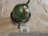 Small globe on metal tripod stand, showing the map details and stand features.