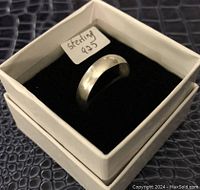 Large sterling silver ring displayed in a jewelry box with a label 'sterling 925'. Shows the polished exterior surface and shape of the band.