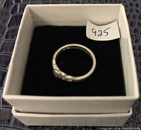 Top view of the sterling silver ring in white box showing 925 paper mark.