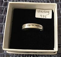 Sterling silver ring displayed inside a white box with black velvet cushioning, labeled 'sterling 925'. View shows ring from a slight angle focusing on inset design.