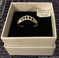 Sterling silver ring with five circular cutouts on the band, displayed upright in a white box with a note 'Sterling 925'.